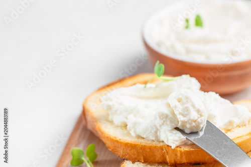 Cream cheese spread on toasted bread with knife