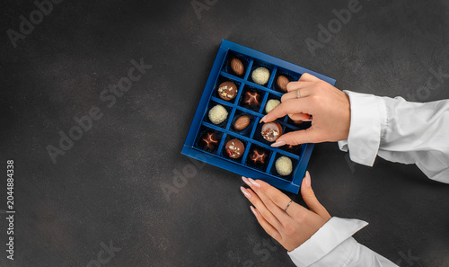 Quadro su tela Woman selecting chocolate from luxury gift box