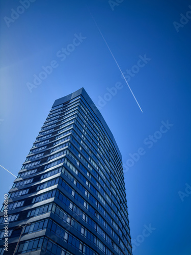 Modern glass skyscraper rising into a clear blue sky