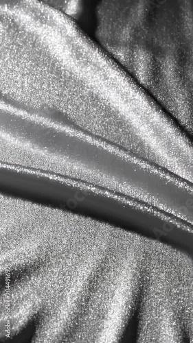 Close-up view of a luxurious, shimmering silver velvet fabric, showcasing its soft texture and elegant folds.