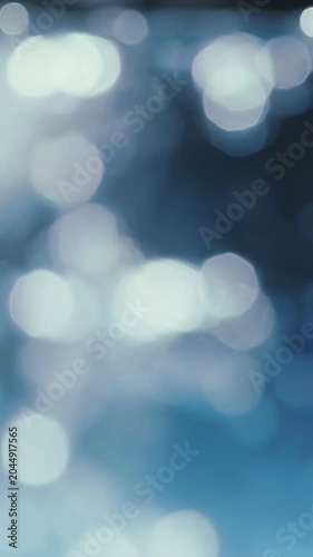 Abstract water surface bokeh lights in cool blue tones, creating a serene and ethereal mood, perfect for backgrounds and digital design.