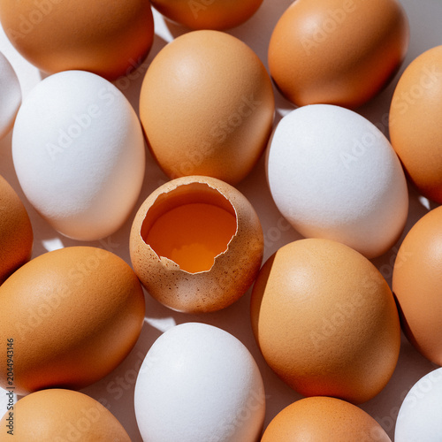 Huevos frescos blancos y cafés con cascarón roto
