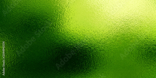 Foto Green beer in a glass with bubbles and foam on a wet green textured background