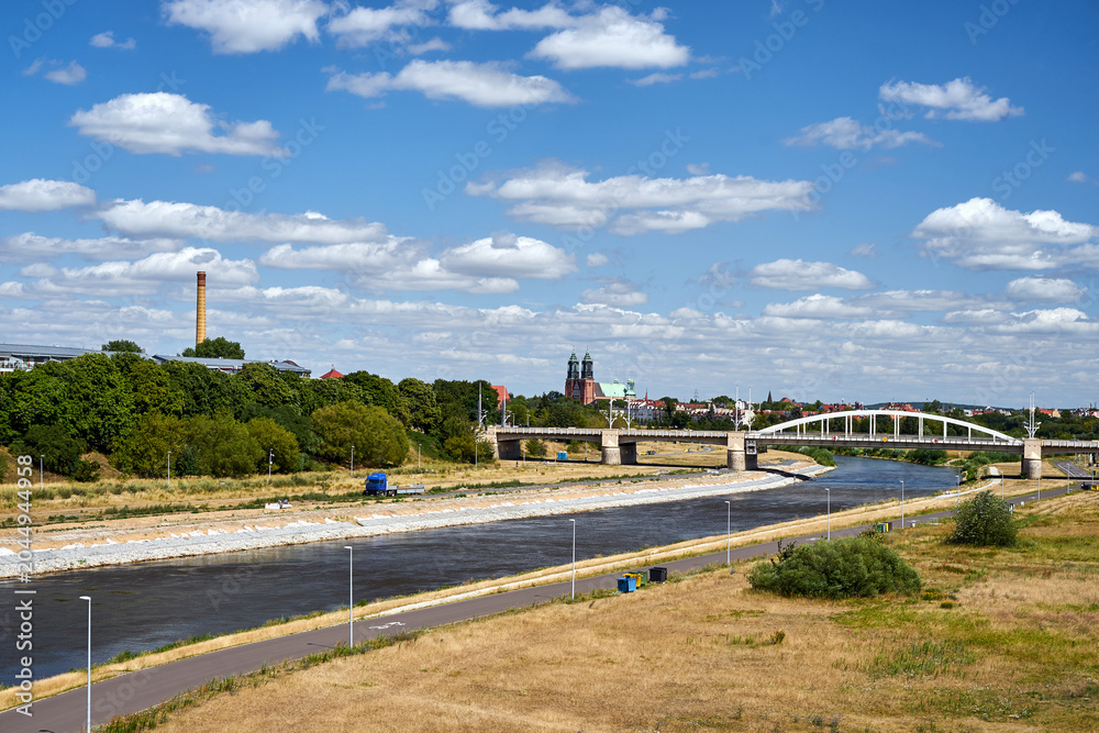 Fototapeta premium Cityscape with a road bridge over the Warta River and the towers of the historic cathedral in Poznan