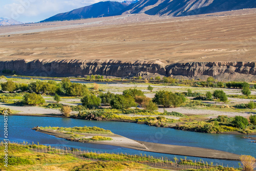 Indus river flowing through green Leh valley, near Leh Airport, Ladakh, India. Leh is capital of Ladakh, Jammu and Kashmir and known for natural landscape attracting tourists from all over world.
