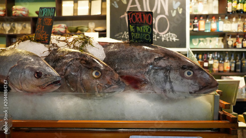 Fresh corvina and fortuno fish on ice display in restaurant