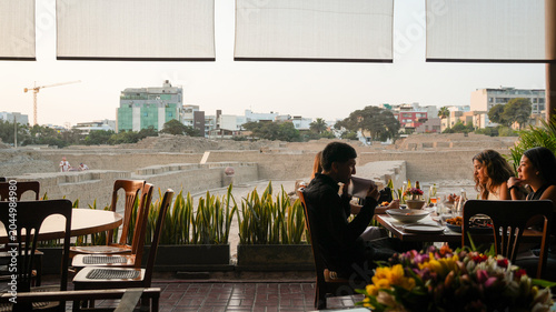 People eating at restaurant overlooking Huaca Pucllana ruins in Lima