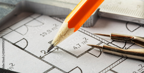 pencil make mark in the architectural blueprints with divider, ruler and caliper. Concept of industrial and real estate construction.