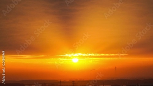 Hazy Sunrise Over Industrial City Skyline With Bridge