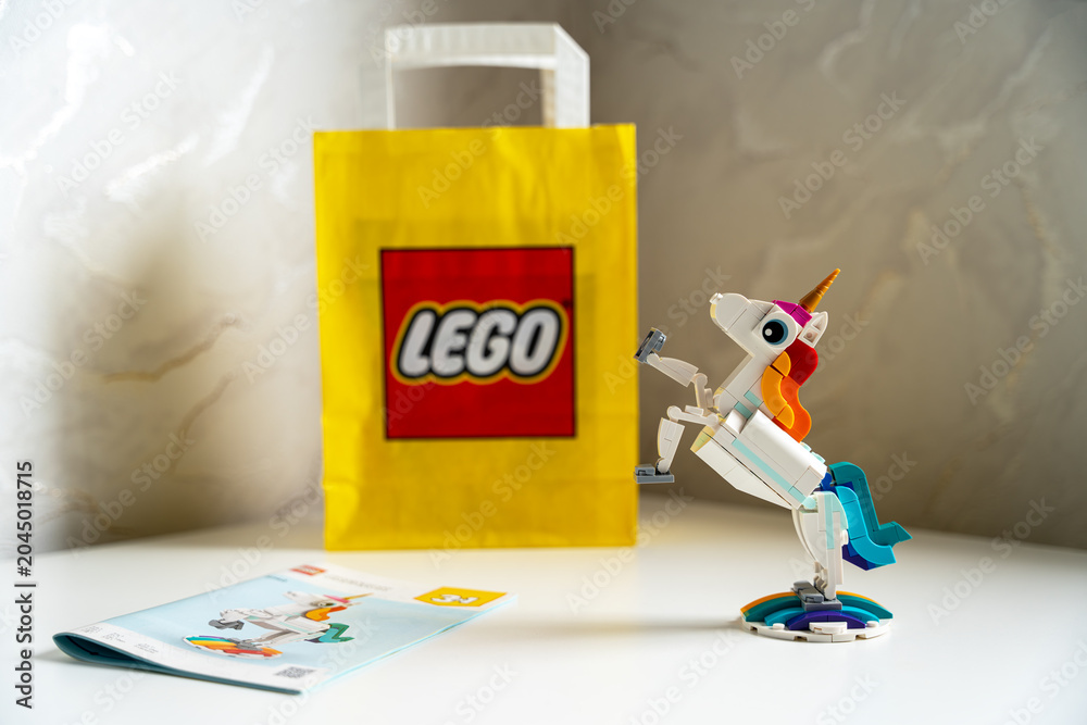 Obraz premium Assembled LEGO Creator 3-in-1 Magical Unicorn on a white table with brand shopping bag and instructions.
