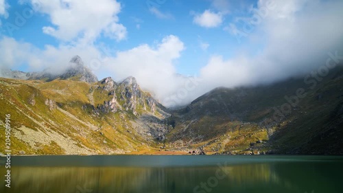 Serene Alpine Lake and Rocky Mountain Peaks Under Clouds
