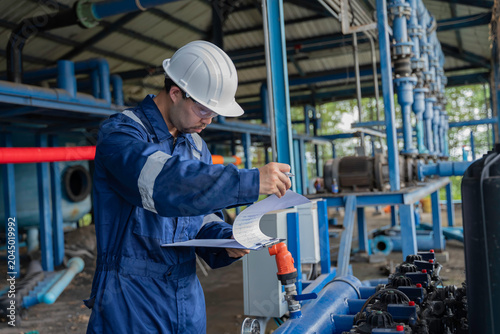 Foto Professional engineer performing maintenance inspection of industrial water filtration system with multiple membrane units