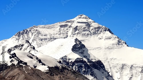Snow-covered Mount Everest peak in the Himalayas under clear blue sky in Mount Everest, Himalayas, Nepal Tibet border