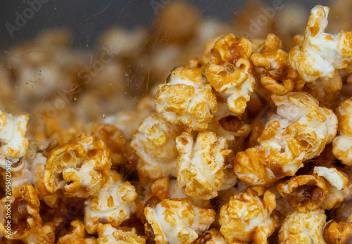 Macro of crunchy caramel popcorn texture. Sweet golden popped corn close up.