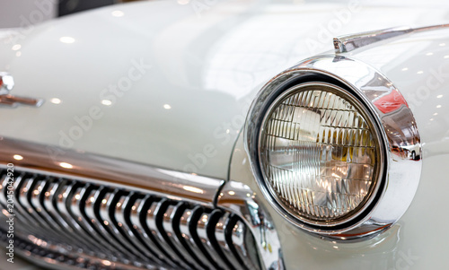 Obraz na plátně Close-up of the round headlamps of a white classic car