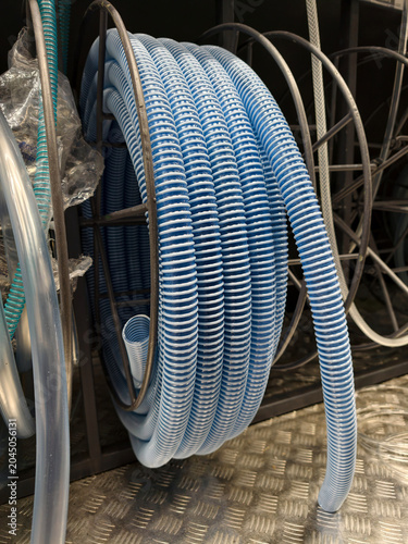 Εκτύπωση καμβά Blue corrugated hose coiled in a tight bundle is displayed in a hardware store a
