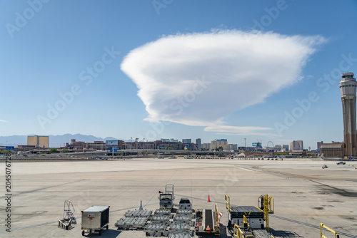 Lenticular clouds  are stationary clouds that form mostly in the troposphere, typically in parallel alignment to the wind direction.  Harry Reid International Airport. Las Vegas, Clark County, Nevada.