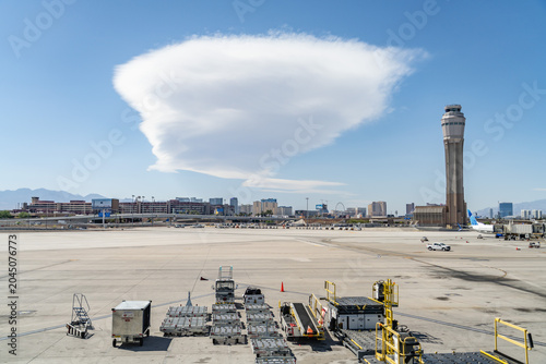Lenticular clouds  are stationary clouds that form mostly in the troposphere, typically in parallel alignment to the wind direction.  Harry Reid International Airport. Las Vegas, Clark County, Nevada.