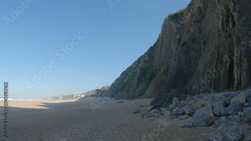 Walking on Golden Sand Beach of Praia Grande do Rodízio with Sea Cliffs and Concrete Seawall, PortugalPOV Walk Across the Wide Sandy Shore of Praia Grande do Rodízio, Sintra, Portugal
