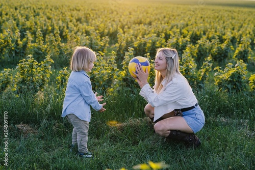 Mother and child playing ball in nature