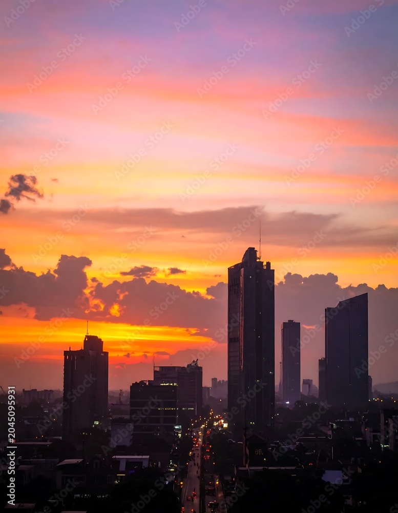 Fototapeta premium Vibrant City Skyline Silhouetted at Sunset in Urban Downtown