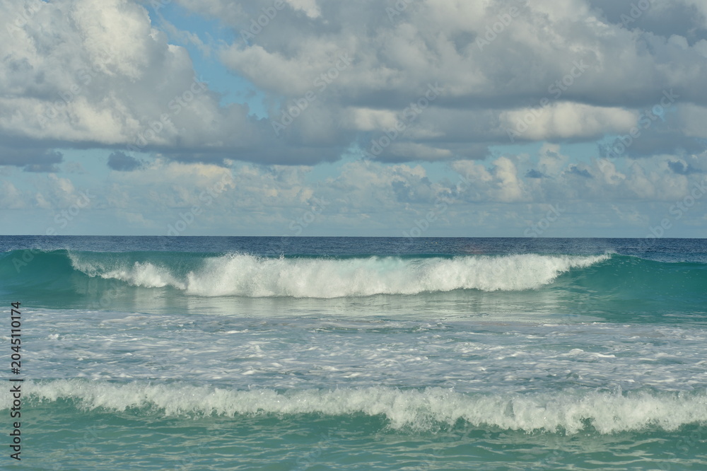 Obraz premium Turquoise sea and gentle waves at a sunlit beach
