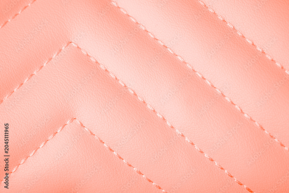 Naklejka premium Soft pastel peach luxurious quilted leather background with elegant precise zigzag stitching pattern