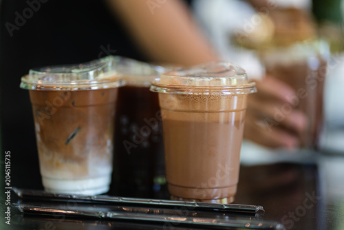 Two glasses of iced coffee and ice chocolate on table in coffee shop.