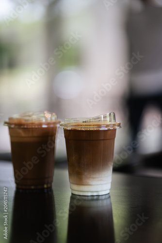 Two glasses of iced coffee on table in coffee shop.