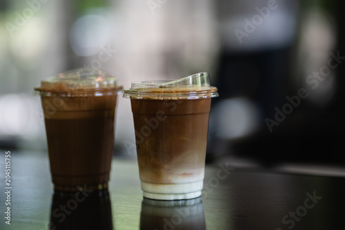 Two glasses of iced coffee on table in coffee shop.