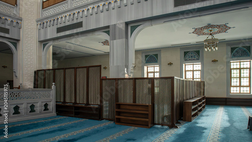 Schilderij op canvas A mosque prayer area features teal carpeting and wooden privacy screens
