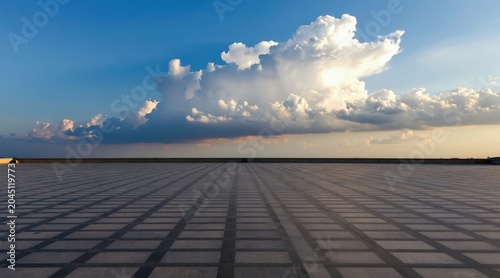 Vast rooftop with checkerboard tiles stretches to horizon under dramatic sky with fluffy clouds. Endless tiled floor leads towards vast sky with sunlit clouds and calm blue expanse.