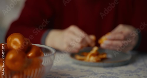 Adult hands breaking a small piece of food over a plate in a cozy home setting