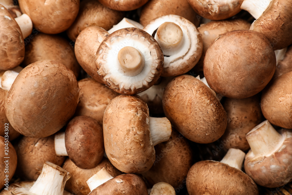 Fototapeta premium Fresh brown champignon mushrooms as background, top view