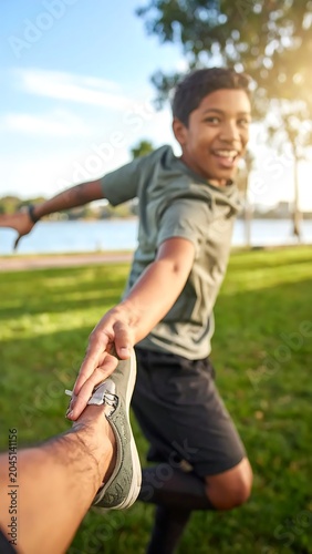 Smiling Young Boy Running While Holding Hand in Sunny Lakeside Park
