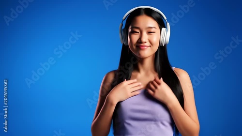 Vibrant woman dancing and pointing at camera with headphones