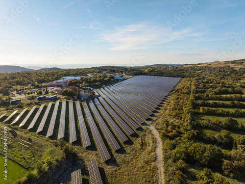 The solar farm features many photovoltaic panels that capture sunlight to produce clean energy, supporting renewable electricity generation.