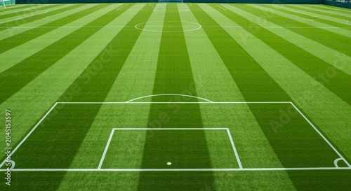 Aerial View of a Football Pitch with Unique Grass Patterns and Central Marking in Green Shades