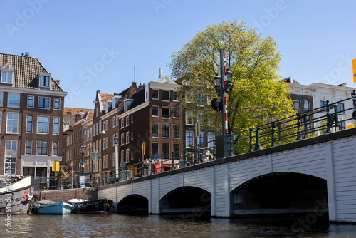 The iconic Skinny Bridge in Amsterdam, Netherlands, viewed from a canal tour, with charming architecture and serene water reflections.