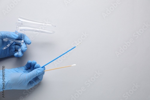фотографія Doctor with vaginal speculum and other gynecology tools on light background, above view
