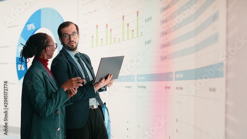 Foto Compiling financial report, laptop and female executive with business partner in conference room, Looking at earnings data, key performance indicators and African American woman with coworker