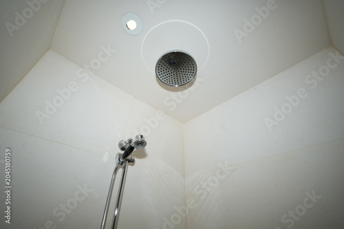 Εκτύπωση καμβά Minimalistic view of a white bathroom corner featuring a ceiling-mounted round s