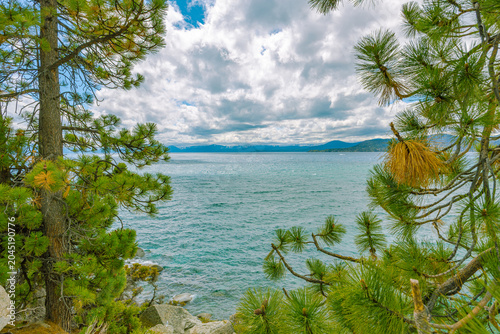 Foto A beautiful view of the expansive blue waters of Lake Tahoe, framed by lush gree