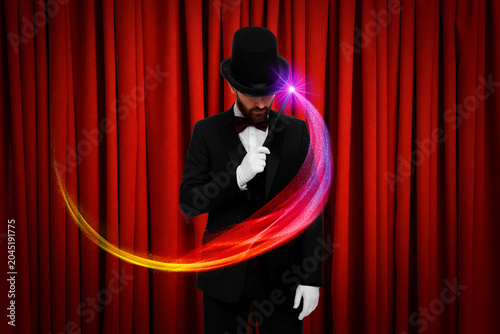Fotografi Magician performing trick on stage with red curtains