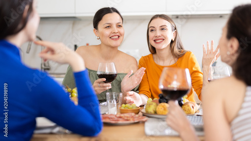 Obraz na płótnie Casual evening where group of cheerful carefree besties sharing wine, dining tog