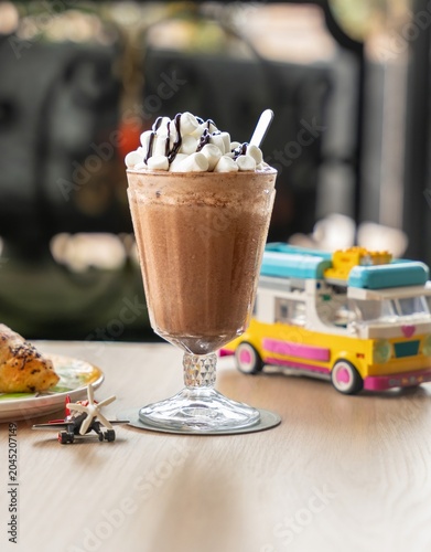 Iced Chocolate Drink with Marshmallows and Chocolate Syrup with cars for kids. Delicious hot chocolate with whipped cream and marshmallows