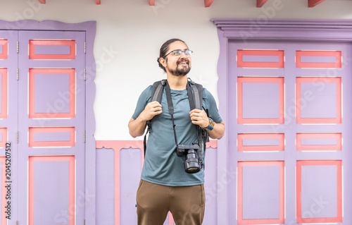 Happy male photographer looking up by colorful doors in Colombia