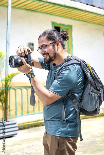 Smiling male photographer taking a picture with professional camera
