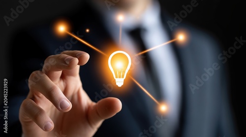 Businessman pointing at glowing light bulb in dark background