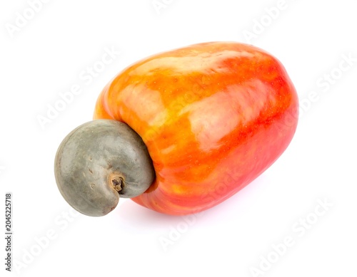 Fresh whole cashew apple fruit with single cashew nut attached, red and white background